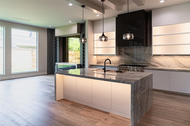 2222 Branard St, Houston, TX 77098 - kitchen featuring white cabinetry, tasteful backsplash, light wood-type flooring, modern cabinets, and a center island with sink