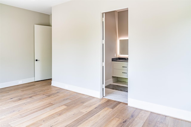 2222 Branard St, Houston, TX 77098 - unfurnished bedroom with light wood finished floors, connected bathroom, and baseboards