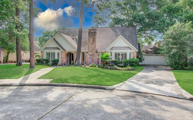 english style home featuring a front lawn, brick siding, a garage, board and batten siding, and a chimney