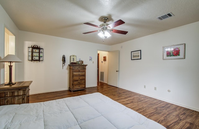 bedroom featuring baseboards, dark wood-style floors, and visible vents