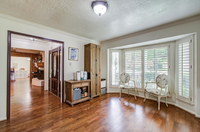 sitting room featuring crown molding, a textured ceiling, and wood finished floors