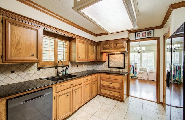 kitchen featuring dark countertops, a chandelier, tasteful backsplash, a sink, and dishwasher