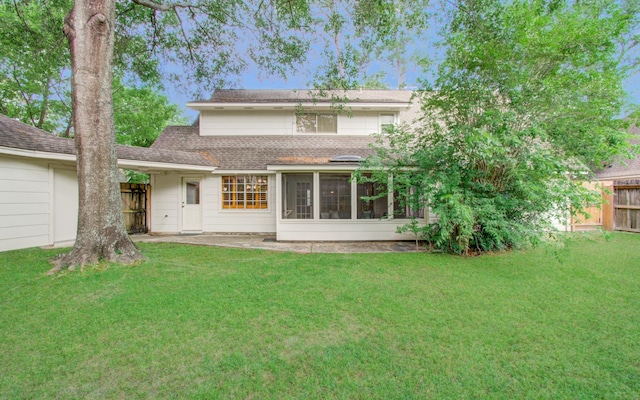 back of house featuring a sunroom, a shingled roof, fence, and a yard