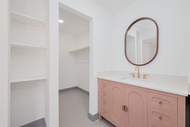 14823 Forest Lodge Dr, Houston, TX 77070 - bathroom with a walk in closet, baseboards, and vanity