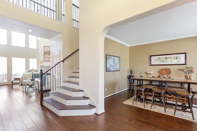 3902 Lakeridge Canyon Dr, Sugar Land, TX 77498 - stairway featuring ornamental molding, wood finished floors, arched walkways, baseboards, and a towering ceiling