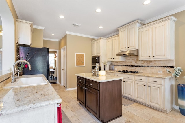 3902 Lakeridge Canyon Dr, Sugar Land, TX 77498 - kitchen with cream cabinets, a sink, under cabinet range hood, black appliances, and backsplash