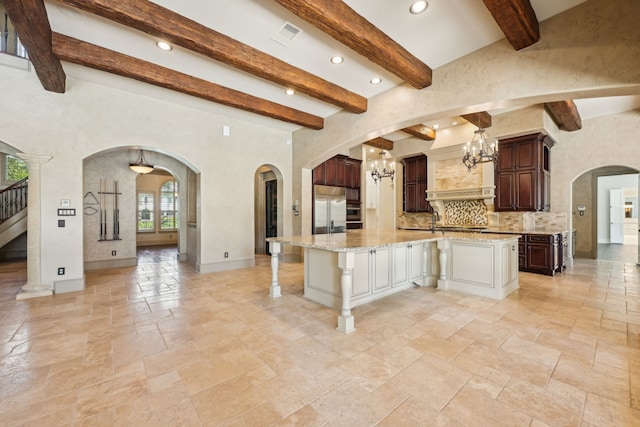 2102 Countryshire Ln, Richmond, TX 77406 - kitchen featuring beam ceiling, tasteful backsplash, stone tile floors, a notable chandelier, and built in refrigerator