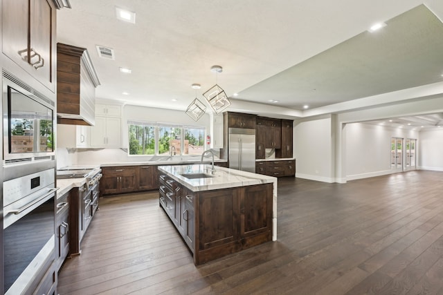 2102 Countryshire Ln, Richmond, TX 77406 - kitchen featuring dark wood-style floors, visible vents, built in appliances, and a sink