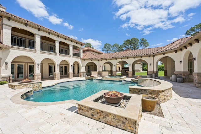 2102 Countryshire Ln, Richmond, TX 77406 - view of swimming pool with french doors, a pool with connected hot tub, a patio, and an outdoor fire pit