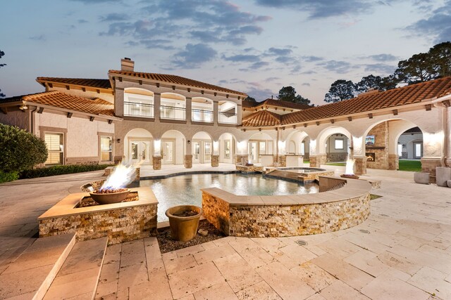 2102 Countryshire Ln, Richmond, TX 77406 - back of house featuring a tiled roof, a chimney, a balcony, a patio, and an outdoor fire pit