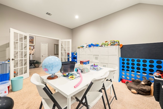 interior space featuring visible vents, carpet floors, french doors, and vaulted ceiling