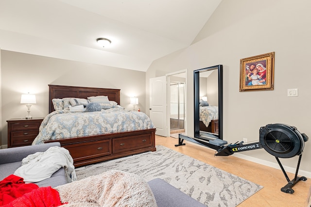 bedroom featuring light tile patterned flooring, vaulted ceiling, and baseboards