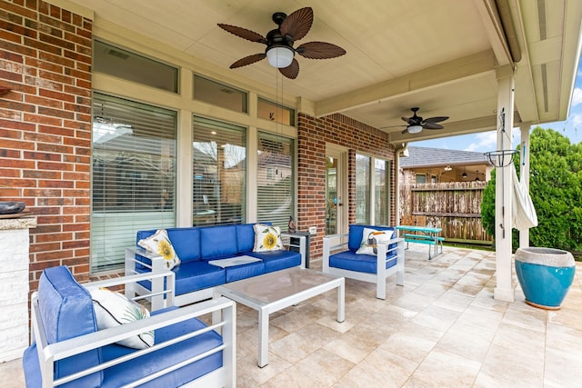 view of patio with an outdoor living space, ceiling fan, and fence