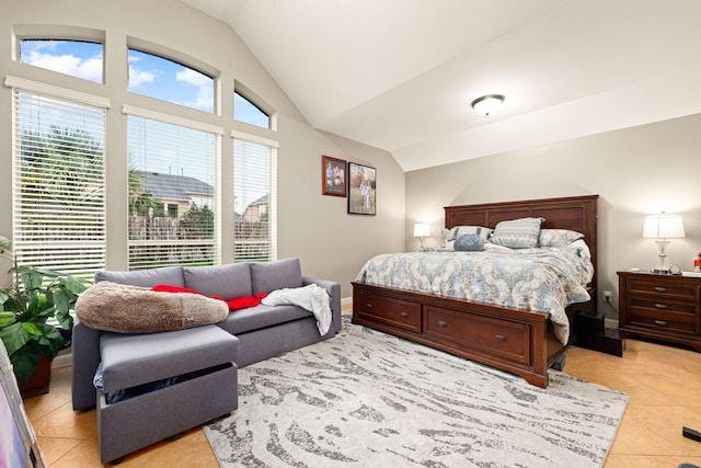 bedroom featuring light tile patterned flooring, vaulted ceiling, and baseboards