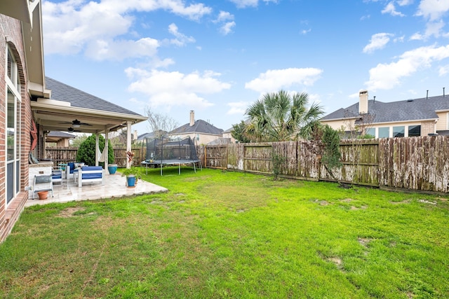 view of yard featuring a fenced backyard, a ceiling fan, a patio, and a trampoline
