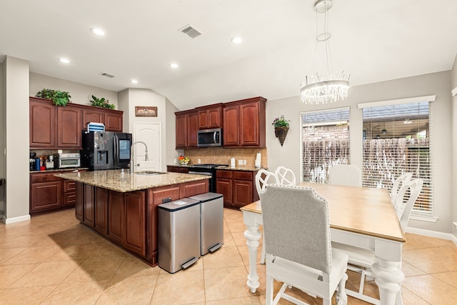 kitchen featuring a notable chandelier, a sink, stainless steel appliances, and decorative backsplash
