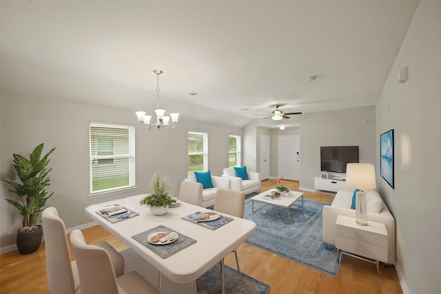 living room featuring light wood-style floors, visible vents, baseboards, and ceiling fan with notable chandelier