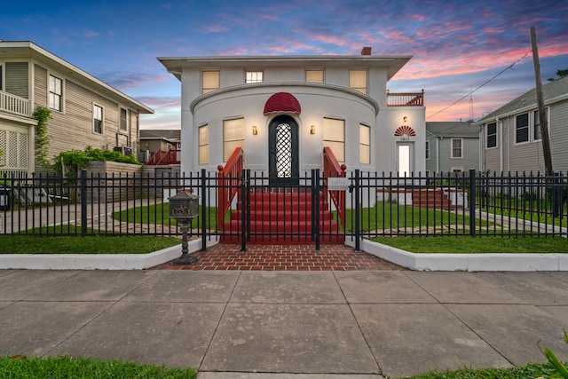 view of front of property featuring a gate, a fenced front yard, and stucco siding