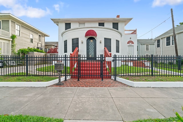 view of front of house with stucco siding, a gate, a chimney, and a fenced front yard