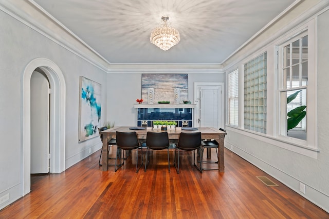 1919 Rosenberg St, Galveston, TX 77550 - dining room featuring crown molding, a chandelier, wood finished floors, baseboards, and arched walkways
