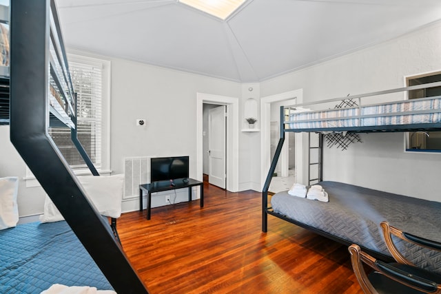 bedroom featuring visible vents, vaulted ceiling, and wood finished floors
