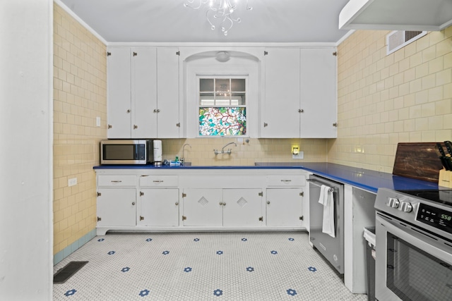kitchen with white cabinetry, stainless steel appliances, and light tile patterned floors