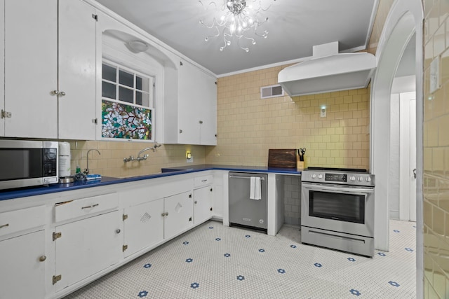 1919 Rosenberg St, Galveston, TX 77550 - kitchen with stainless steel appliances, a sink, white cabinets, crown molding, and tasteful backsplash