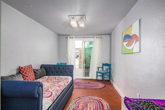 bedroom with a textured wall, baseboards, a textured ceiling, and access to exterior
