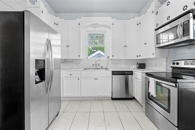 1919 Rosenberg St, Galveston, TX 77550 - kitchen featuring appliances with stainless steel finishes, a sink, white cabinetry, and backsplash
