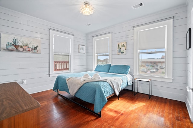 1919 Rosenberg St, Galveston, TX 77550 - bedroom featuring wood walls, hardwood / wood-style flooring, and a chandelier