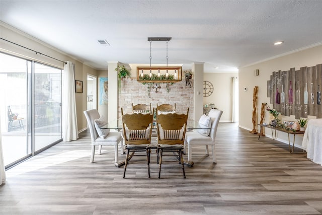 dining area with wood finished floors, visible vents, and plenty of natural light