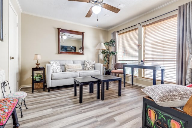 living area featuring ornamental molding, baseboards, a ceiling fan, and light wood-style floors