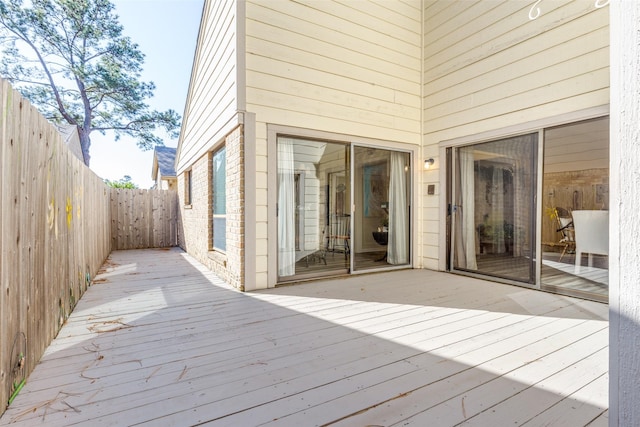 wooden deck with a fenced backyard