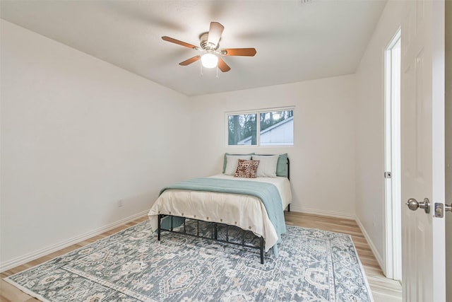 105 E Wavy Oak Cir, The Woodlands, TX 77381 - bedroom with light wood-style flooring, baseboards, and ceiling fan
