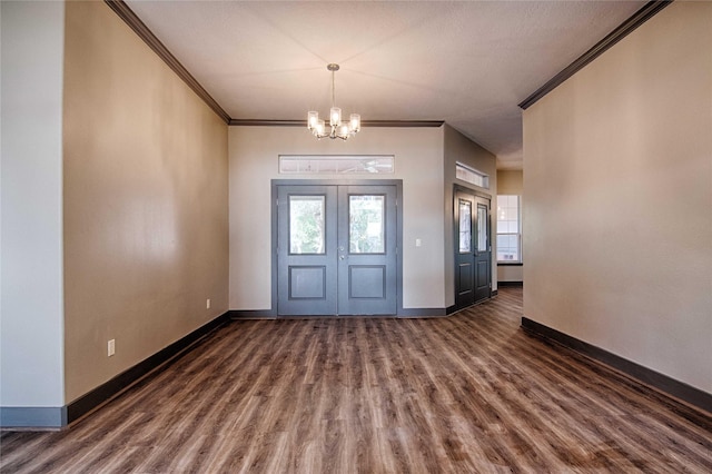250 Bucek Ln, Schulenburg, TX 78956 - foyer entrance featuring crown molding, baseboards, dark wood-style floors, and an inviting chandelier