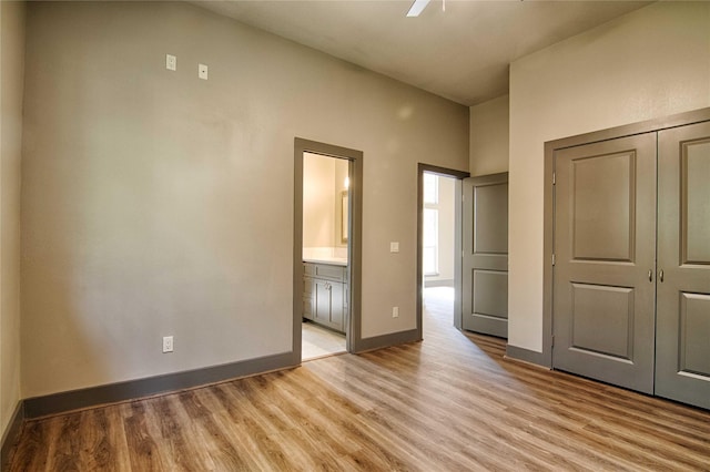 250 Bucek Ln, Schulenburg, TX 78956 - unfurnished bedroom featuring ensuite bathroom, a closet, light wood finished floors, a ceiling fan, and baseboards