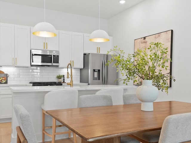 dining area featuring light wood finished floors and recessed lighting