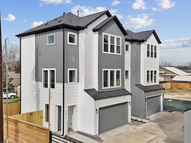 view of front of home featuring board and batten siding, a shingled roof, fence, a garage, and a standing seam roof