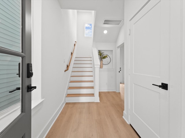 staircase featuring wood finished floors and baseboards