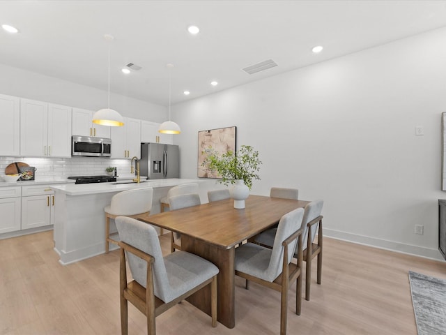 dining room with light wood-style flooring, visible vents, and recessed lighting
