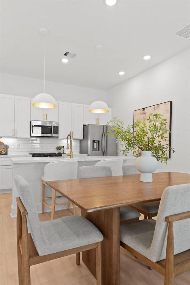 dining room featuring visible vents, recessed lighting, and light wood-style floors