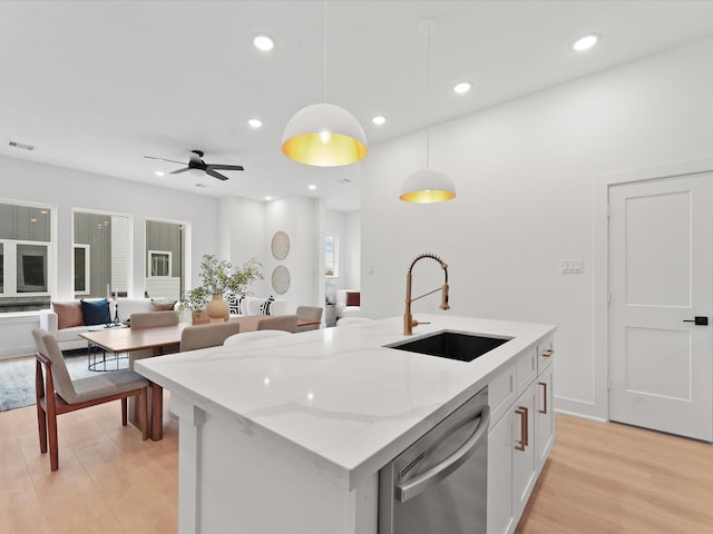 kitchen featuring light wood-style flooring, a sink, visible vents, dishwasher, and hanging light fixtures