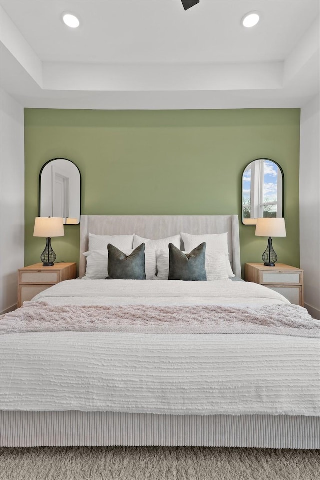 bedroom with baseboards, recessed lighting, and a raised ceiling