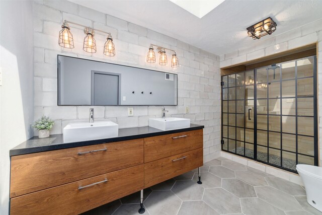 8924 Chatsworth Dr, Houston, TX 77024 - full bathroom featuring double vanity, tile patterned floors, and toilet
