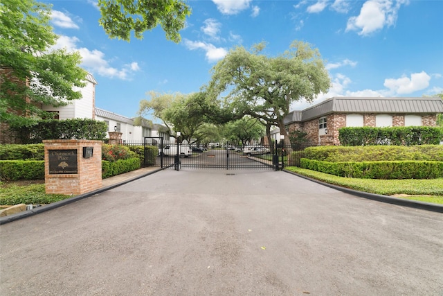 8924 Chatsworth Dr, Houston, TX 77024 - view of asphalt street with a gate, curbs, a gated entry, and a residential view
