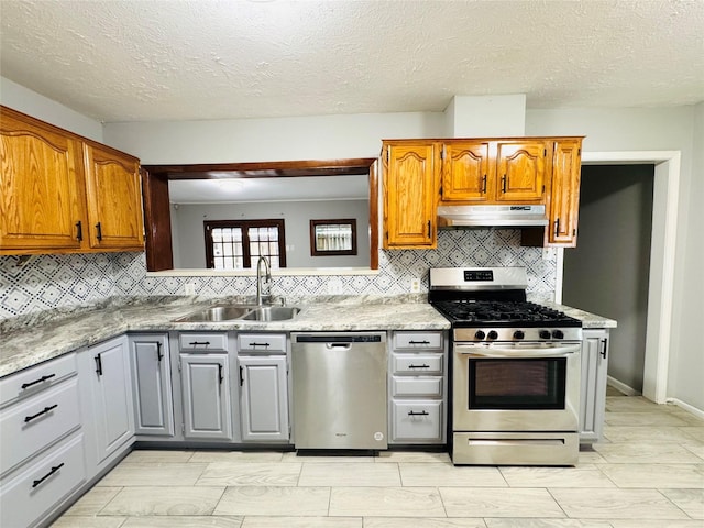 7905 Turquoise Ln, Houston, TX 77055 - kitchen featuring appliances with stainless steel finishes, a sink, under cabinet range hood, tasteful backsplash, and a textured ceiling