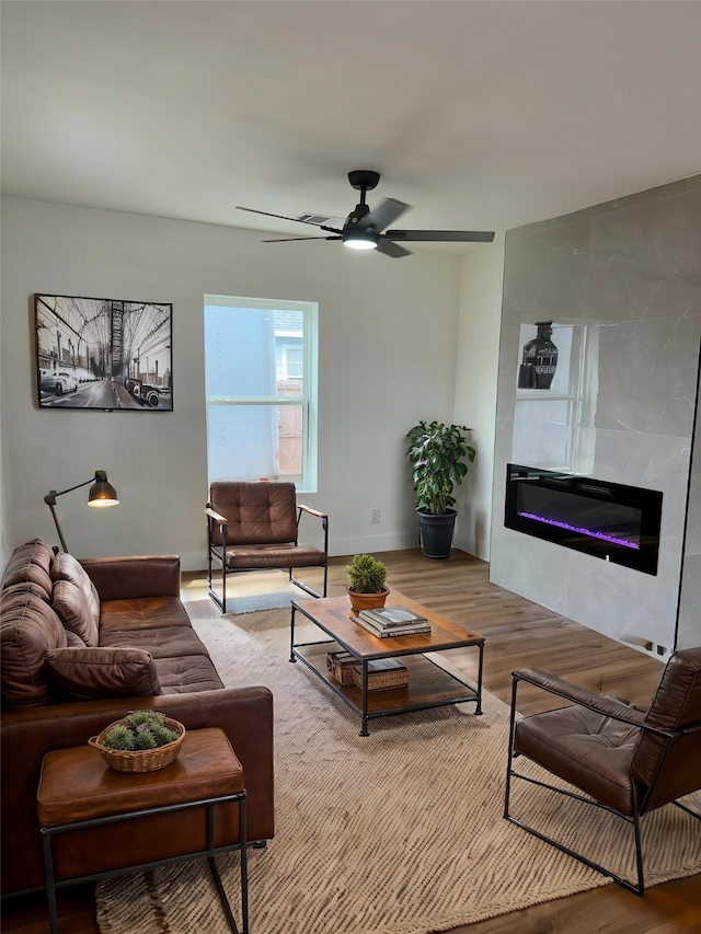 4414 Orange St, Houston, TX 77020 - living area with baseboards, a ceiling fan, a glass covered fireplace, and wood finished floors