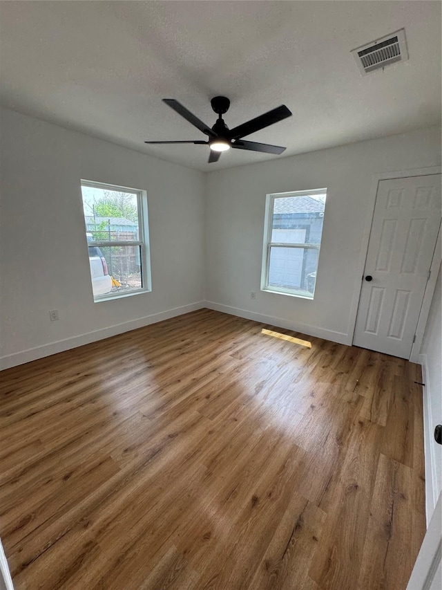 4414 Orange St, Houston, TX 77020 - unfurnished bedroom featuring baseboards, visible vents, multiple windows, and wood finished floors