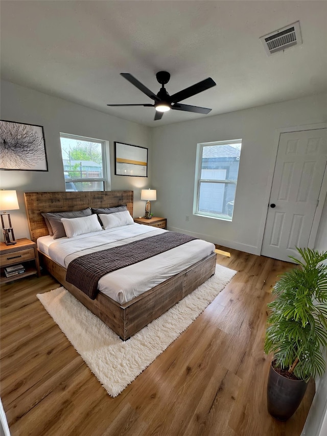 4414 Orange St, Houston, TX 77020 - bedroom featuring baseboards, visible vents, multiple windows, and wood finished floors