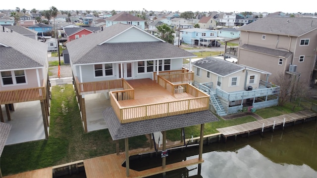 back of property with a shingled roof, a deck with water view, and a residential view